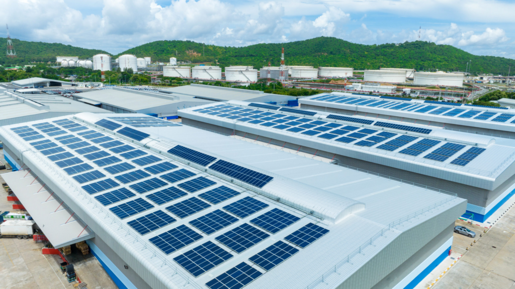 Grootschalige installatie van industriële zonnepanelen op een plat bedrijfsdak voor energie-autonomie.