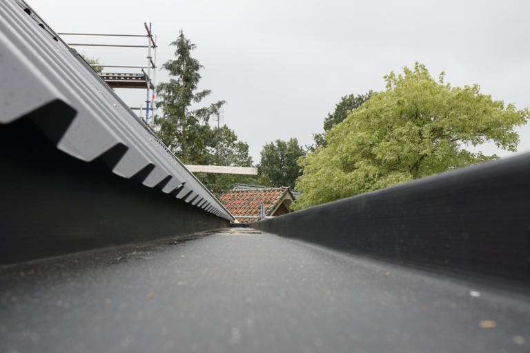Professionele installatie van EPDM dakgoten en afvoersystemen voor een optimale hemelwaterafvoer bij industriële panden.